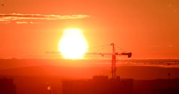 Tornkran mot bakgrund av den nedgående solen. Bakgrundsbelysning. Ekaterinburg, Ryssland — Stockfoto