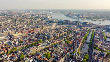 Amsterdam, Hollanda. Amsterdam Merkez İstasyonu (Amsterdam Centraal) doğru şehir çatıları üzerinde Uçan , Havadan Görünümü 