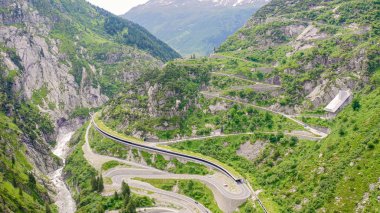 İsviçre. Andermatt 'ın arkasındaki dağ manzarası. Tünelleri, Gotthardstrasse 'si ve hava manzarası olan resimli dolambaçlı dağ yolu. 