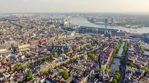 Amsterdam, Netherlands. Flying over the city rooftops towards Amsterdam Central Station ( Amsterdam Centraal ), Aerial View