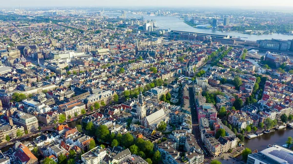 Amsterdam, Hollanda. Amsterdam Merkez İstasyonu (Amsterdam Centraal) doğru şehir çatıları üzerinde Uçan , Havadan Görünümü — Stok fotoğraf