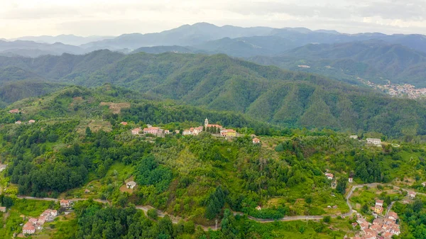 De Italia. Bosque cubierto de montañas y villas. Iglesia de San Michele Arcangelo. Borghetto di Vara territorio en la región de Liguria, en la provincia de La Spezia, Vista aérea — Foto de Stock