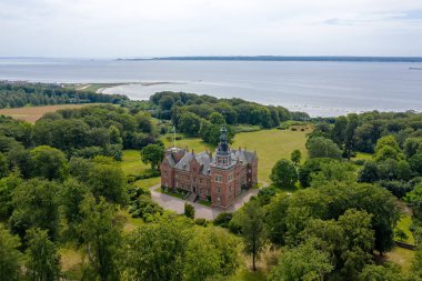 İsveç. Sahildeki şato, ormanın ortasında.