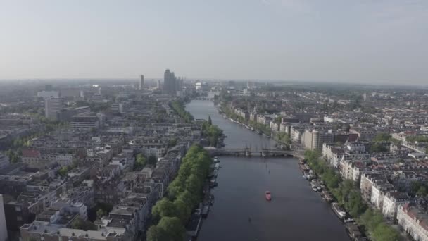 Амстердам, Нідерланди. Пролетівши над містом дахи. Амстел річки. 4K — стокове відео