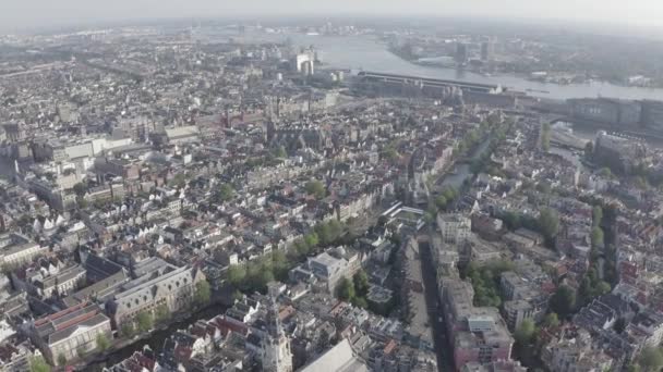 Амстердам, Нидерланды. Полет над крышами города в направлении Центрального вокзала Амстердама (Amsterdam Centraal). 4K — стоковое видео