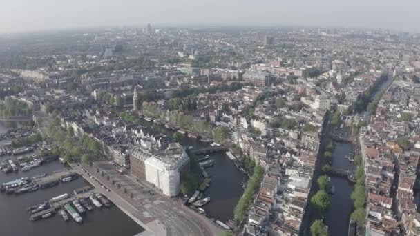 Amesterdão, Países Baixos. Voando sobre os telhados da cidade em direção à Estação Central de Amesterdão (Amsterdam Centraal). 4K — Vídeo de Stock