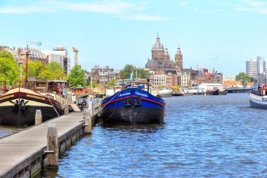 Amsterdam, Netherlands - June 30, 2019: Oosterdok, Prins Hendrikkade Waterfront. Amsterdam historic city center in the morning