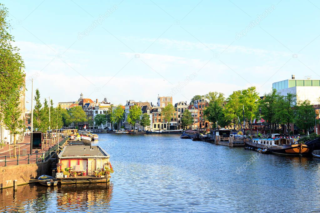 Amsterdam, Netherlands. Residential barges and houses on the water. Canal (street) Amstel.The historic city center.