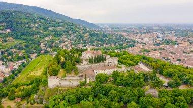Brescia, İtalya. Castello di Brescia. Bulutlu havada şehrin üzerinden uçmak, Hava Görünümü  