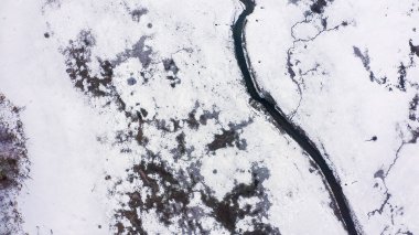 Karla kaplı küçük bir nehri olan bataklıklar. Birçok vahşi hayvanın ayak izleri, Havadan Bakış  