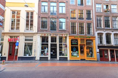 Amsterdam, Hollanda - 30 Haziran 2019: Şehrin eski evleri. Prezervatif ve kahve dükkanı vitrini.