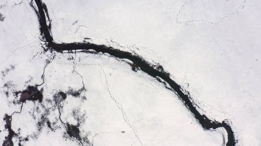 Karla kaplı küçük bir nehri olan bataklıklar. Vahşi hayvanların pek çok ayak izi, Havadan Bakış, Kafadan Vurma  