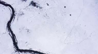 Karla kaplı küçük bir nehri olan bataklıklar. Vahşi hayvanların pek çok ayak izi, Havadan Bakış, Kafadan Vurma  