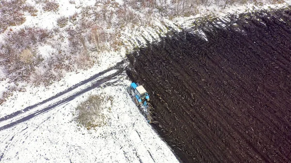 Ein Blauer Traktor Pflügt Ein Schneebedecktes Feld Hinter Dem Traktor — Stockfoto