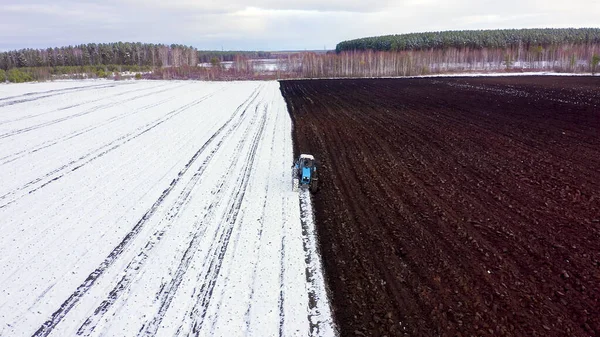 Ein Blauer Traktor Pflügt Ein Schneebedecktes Feld Hinter Dem Traktor — Stockfoto