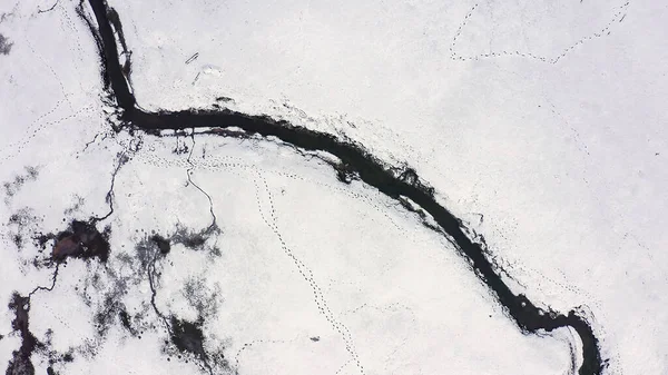 Karla kaplı küçük bir nehri olan bataklıklar. Vahşi hayvanların pek çok ayak izi, Havadan Bakış, Kafadan Vurma  