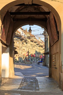 Bern, İsviçre - 14 Temmuz 2019: Zytglogge kulesinin kemerinden bakın. Şehirdeki dükkanları ve kafeleri olan merkez turist caddesi. Spitalgasse