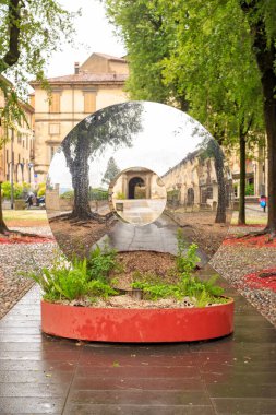 Bergamo, İtalya - 15 Temmuz 2019: Parktaki Piazza Lorenzo 'da yansıtıcı disk şeklinde heykel. Yağmurlu hava
