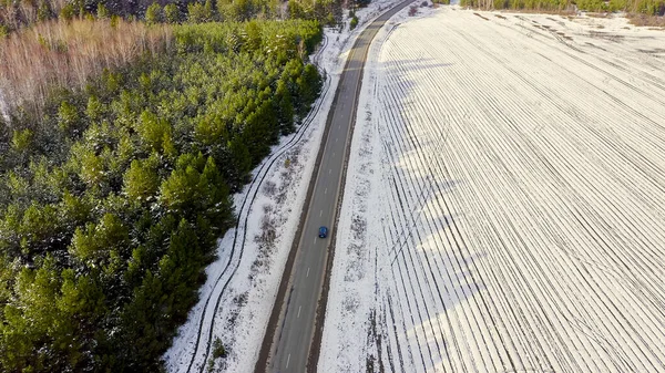 道路上の青い車に乗る 畑や森の周りは雪に覆われています ロシア ウラル 空中ビュー — ストック写真
