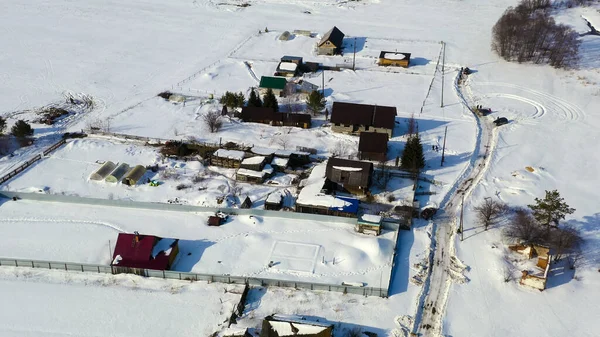 冬に空を飛ぶ 雪の下で古い家と村 ロシア 空中ビュー — ストック写真