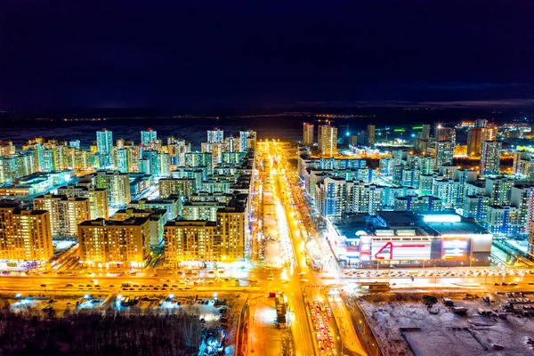 Yekaterinburg, Rusya. Yaya geçitli fenerlerle aydınlatılmış geniş bir otoyol. Yeni binaları olan bir yerleşim yeri. Gece şehir manzarası