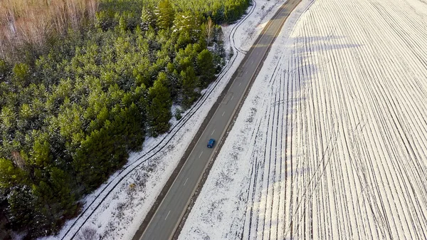 道路上の青い車に乗る 畑や森の周りは雪に覆われています ロシア ウラル 空中ビュー — ストック写真