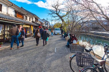 Okayama, Japonya - 30 Aralık 2018: Kurashiki Bikan Tarihi Bölgesi. Kurashiki Nehri 'nin kıyılarında söğüt ağaçları ve konutlardan oluşan Japon beyaz duvarlarıyla bilinen şehir manzarası