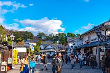 Okayama, Japonya - 30 Aralık 2018: Kurashiki Bikan Tarihi Bölgesi. Kurashiki Nehri 'nin kıyılarında söğüt ağaçları ve konutlardan oluşan Japon beyaz duvarlarıyla bilinen şehir manzarası
