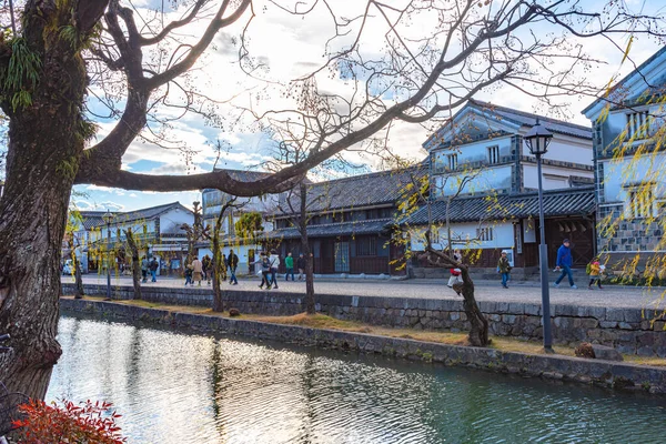 Okayama, Japão - 30 de dezembro de 2018: Vista do bairro histórico Kurashiki Bikan. Paisagem urbana conhecida por muros brancos caracteristicamente japoneses de residências e salgueiros que revestem margens do rio Kurashiki — Fotografia de Stock