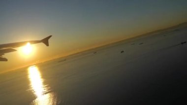 Zaman atlamalı video. Tokyo Haneda Uluslararası Havalimanı 'ndan gün doğumunda kalkan uçak. Yokohama Şehri, Kawasaki şehri ve mavi gökyüzü arkaplanı olan Ota şehri, Tokyo, Japonya