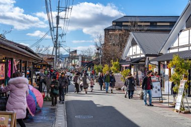 Yufuin, Oita Bölgesi, Japonya - 5 Ocak 2020: Açık mavi gökyüzü ile kış güneşli bir günde Yufuin şehri. Sokakta bir sürü dükkan var, turistler yeni yıl tatili için buraya geliyor.