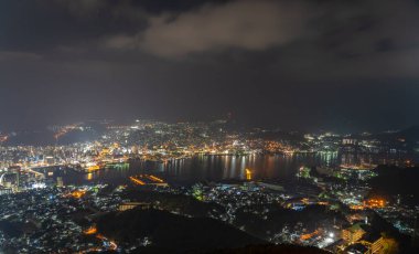 Nagasaki şehri geceleri aydınlanıyor. Inasa Dağı 'nın gözlem platformundan Panorama gece manzarası. Dünyanın en ünlü güzellik manzaralı yeri, 10 milyon dolarlık gece gösterimi. Nagasaki Bölgesi, Japonya