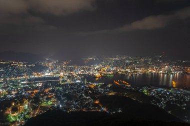 Nagasaki şehri geceleri aydınlanıyor. Inasa Dağı 'nın gözlem platformundan Panorama gece manzarası. Dünyanın en ünlü güzellik manzaralı yeri, 10 milyon dolarlık gece gösterimi. Nagasaki Bölgesi, Japonya