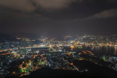 Nagasaki şehri geceleri aydınlanıyor. Inasa Dağı 'nın gözlem platformundan Panorama gece manzarası. Dünyanın en ünlü güzellik manzaralı yeri, 10 milyon dolarlık gece gösterimi. Nagasaki Bölgesi, Japonya