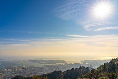 Kobe şehri panoramik manzarası. Maya Kikusedai parkı gözlemevi platformu güneşli bir gün batımı saatinde mavi gökyüzü arkaplanıyla, 10 milyon dolarlık gece görüşleriyle ünlüdür. Hyogo Bölgesi, Japonya
