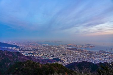 Kobe şehri panoramik manzarası. Maya Kikusedai parkı gözlemevi platformu güneşli bir gün batımı saatinde mavi gökyüzü arkaplanıyla, 10 milyon dolarlık gece görüşleriyle ünlüdür. Hyogo Bölgesi, Japonya