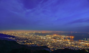 Kobe şehri panoramik manzarası. Maya Kikusedai parkı gözlemevi platformu güneşli bir gün batımı saatinde mavi gökyüzü arkaplanıyla, 10 milyon dolarlık gece görüşleriyle ünlüdür. Hyogo Bölgesi, Japonya