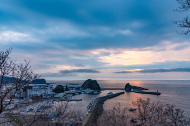 Hokkaido, Japan - May 05 2019 : View of Utoro fishing port in springtime with Shiretoko mountain range at Utoronishi. Town Shari, Shiretoko Peninsula