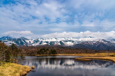 Baharın güneşli günlerinde güzel göl ve yuvarlanan dağ sıraları. Yüksek enlem ülkesi doğal güzellik manzarası. Shiretoko Goko 'nun ilk gölü, Shiretoko Ulusal Parkı. Hokkaido, Japonya