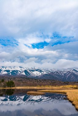 Baharın güneşli günlerinde güzel göl ve yuvarlanan dağ sıraları. Yüksek enlem ülkesi doğal güzellik manzarası. Shiretoko Goko 'nun ilk gölü, Shiretoko Ulusal Parkı. Hokkaido, Japonya