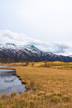 Baharın güneşli günlerinde güzel göl ve yuvarlanan dağ sıraları. Yüksek enlem ülkesi doğal güzellik manzarası. Shiretoko Goko 'nun ilk gölü, Shiretoko Ulusal Parkı. Hokkaido, Japonya