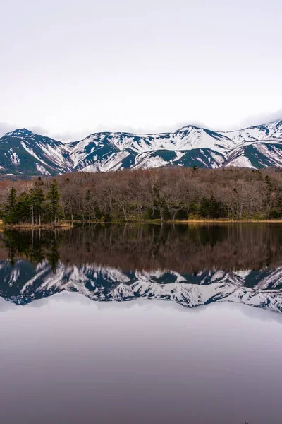 春の晴れた日を背景に 鏡のように青い空を反映した美しい湖 圧延山の範囲と森林 標高の高い国 自然美景 — ストック写真