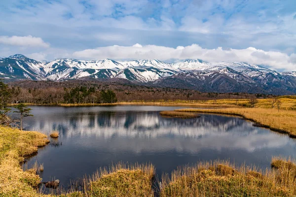 Beautiful lake and rolling mountain range on springtime sunny day. High latitude country natural beauty scenery. The First Lake of Shiretoko Goko Five Lakes, Shiretoko National Park. Hokkaido, Japan