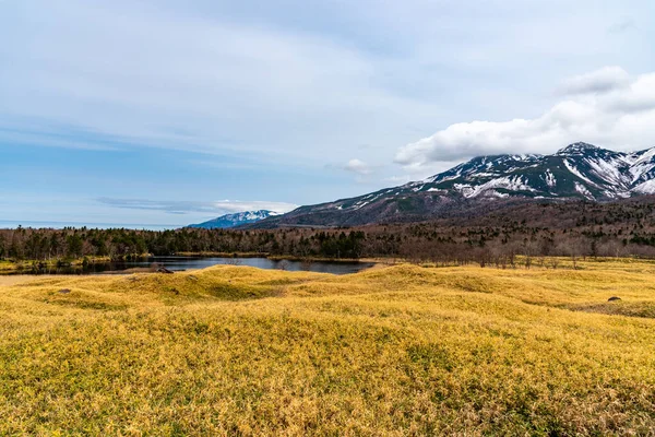 Beautiful lake and rolling mountain range on springtime sunny day. High latitude country natural beauty scenery. The First Lake of Shiretoko Goko Five Lakes, Shiretoko National Park. Hokkaido, Japan