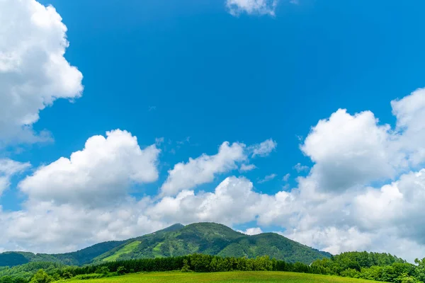Mt. Niseko-Annupuri en primavera día soleado. Paisajes de naturaleza rural, cielo azul y nubes blancas sobre fondo. Ciudad Niseko, Subprefectura de Shiribeshi, Hokkaido, Japón — Foto de Stock