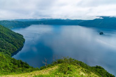 Mashu Gölü izleme platformunun doğal manzarası. Gölün yüzeyi genellikle yaz mevsiminde sisle kaplanarak gölün gizemliliğiyle ünlüdür. Akan Mashu Ulusal Parkı, Hokkaido, Japonya