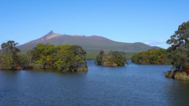 Güneşli bir günde Onuma Gölü 'nden manzara. Hokkaido Koma-ga-take ve arka planda açık mavi gökyüzü. Onuma Quasi Ulusal Parkı. Nanae Kasabası, Oshima Bölgesi, Hokkaido, Japonya