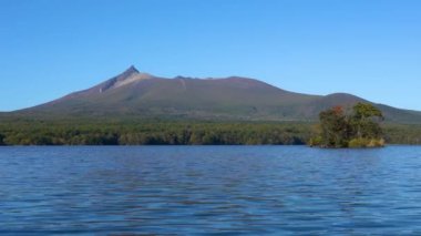 Güneşli bir günde Onuma Gölü 'nden manzara. Hokkaido Koma-ga-take ve arka planda açık mavi gökyüzü. Onuma Quasi Ulusal Parkı. Nanae Kasabası, Oshima Bölgesi, Hokkaido, Japonya