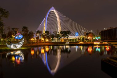 Taichung City, Taiwan - APR 11, 2020 : Nightscape of new landmark Konan Ai-Qin Bridge, Taichung Central Park at the Xitun District Shuinan Economic and Trade Area. The second largest park in Taiwan clipart