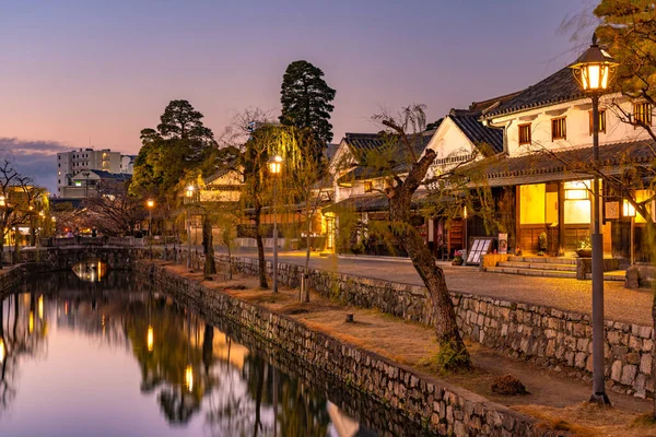 Prefectura de Okayama, Japón - 27 dic 2019: Kurashiki Bikan Historical Quarter in dusk. Townscape conocido por las paredes blancas característicamente japonesas de residencias y sauces que bordean las orillas del río — Foto de Stock